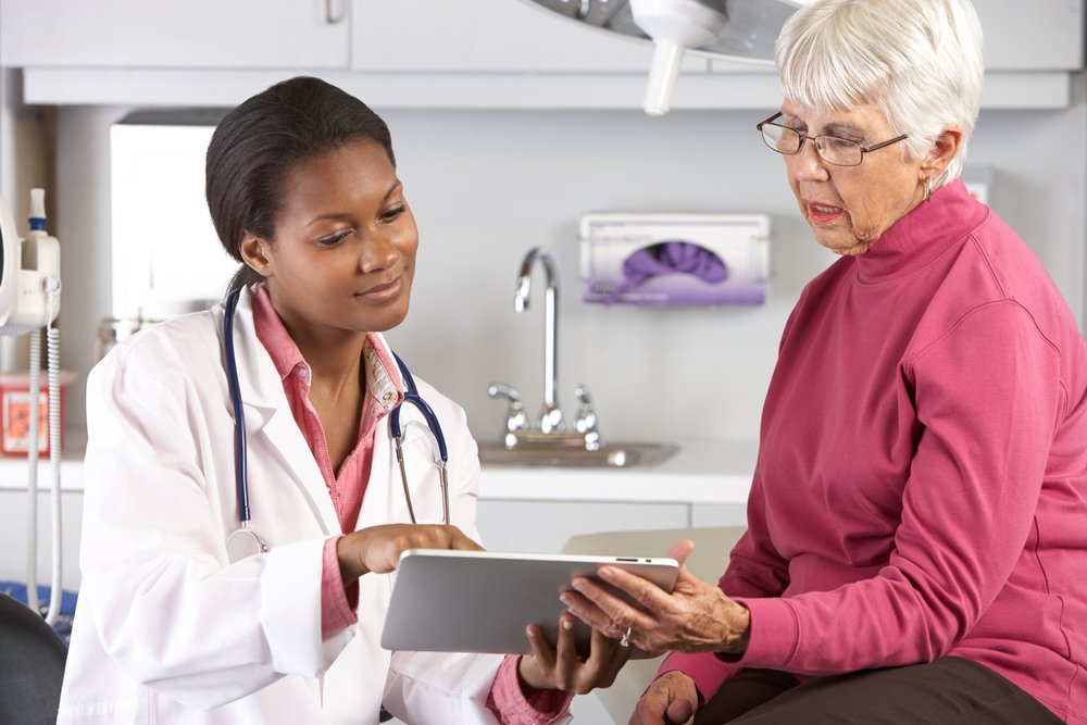 Senior woman meeting with a healthcare provider to discuss Medicare options and the importance of understanding different types of medical visits in the context of estate planning and elder law.