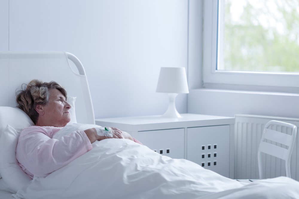 Elderly woman lying in a hospice care bed, illustrating the challenges and deficiencies in hospice services highlighted by recent government reports.