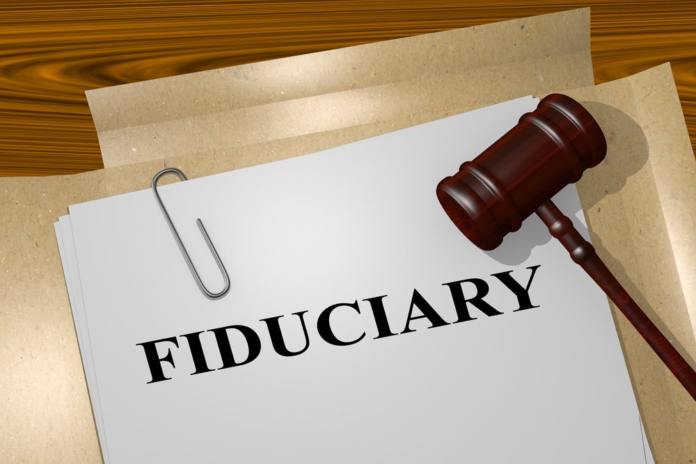 A thoughtful individual reviewing estate planning documents, highlighting the importance of selecting the right fiduciary to manage personal affairs impartially.