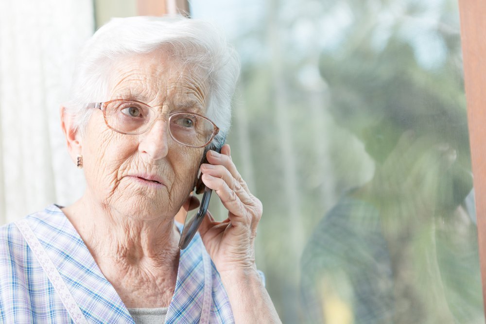 A woman uses a smartphone to communicate with a family member in a nursing home, showcasing the importance of staying connected through technology amidst COVID-19 visitor restrictions.