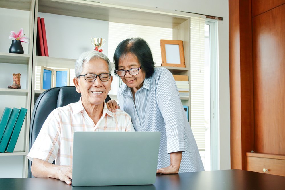 An elderly couple sitting together outdoors, representing the importance of strategic Social Security decisions in estate planning to secure financial stability for surviving spouses.
