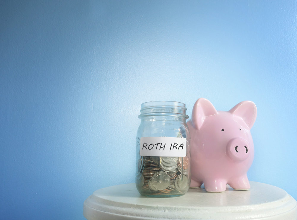 A piggy bank symbolizing wealth accumulation sits next to a document labeled Roth IRA, representing its role in estate planning and tax-free inheritance strategies.