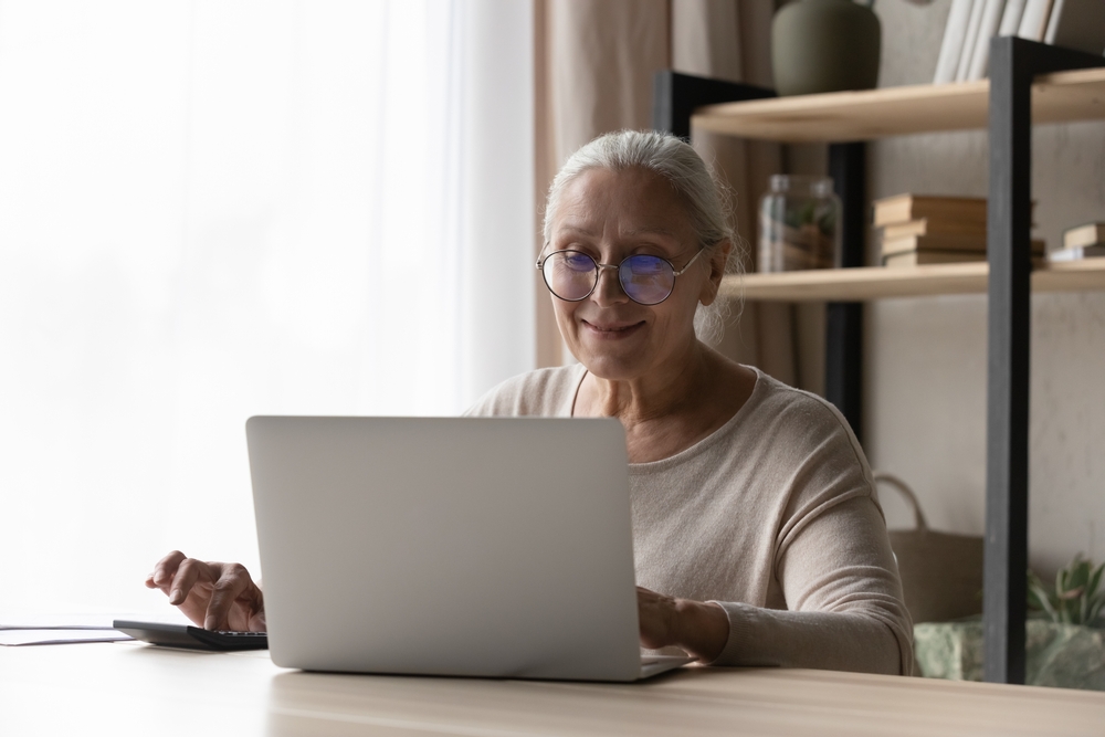 Senior woman calculating Medigap insurance options to compare premiums and benefits for estate planning and elder law considerations.