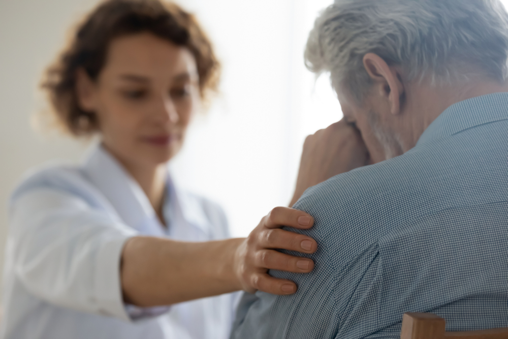 A female doctor gently comforting an elderly woman, illustrating the significance of preparing Psychiatric Advance Directives to ensure proper mental health treatment for seniors during a crisis.