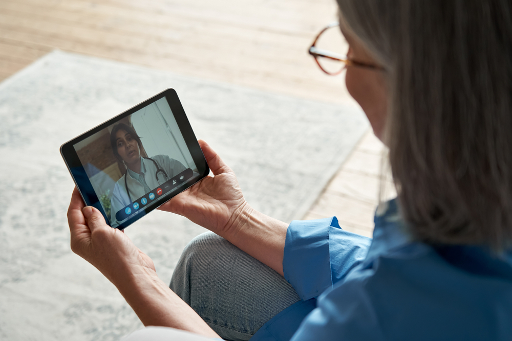 Elderly patient video calling with a doctor on a tablet, showcasing the effectiveness of telehealth services in providing medical advice remotely.