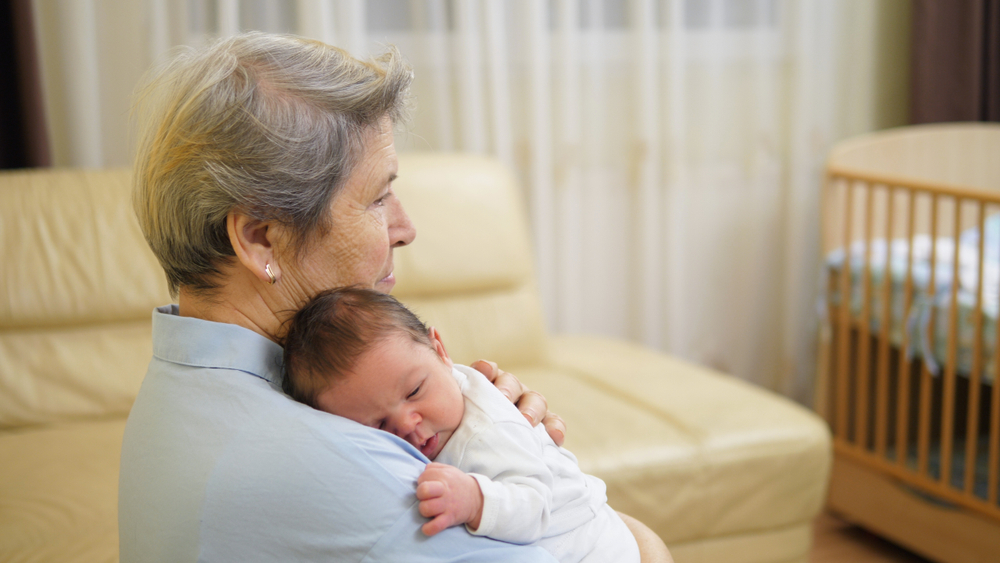 Grandmother holding a newborn baby, highlighting grandparent caregiving and the importance of family connections in estate planning and elder law.