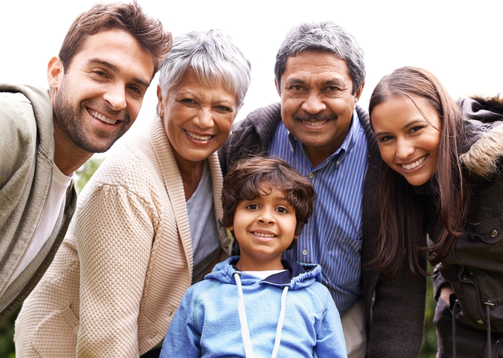 A smiling multi-generational family poses for a self-portrait, highlighting the value of family legacy and preparedness in estate planning and elder law. The image reflects the importance of securing a future for loved ones in uncertain times.