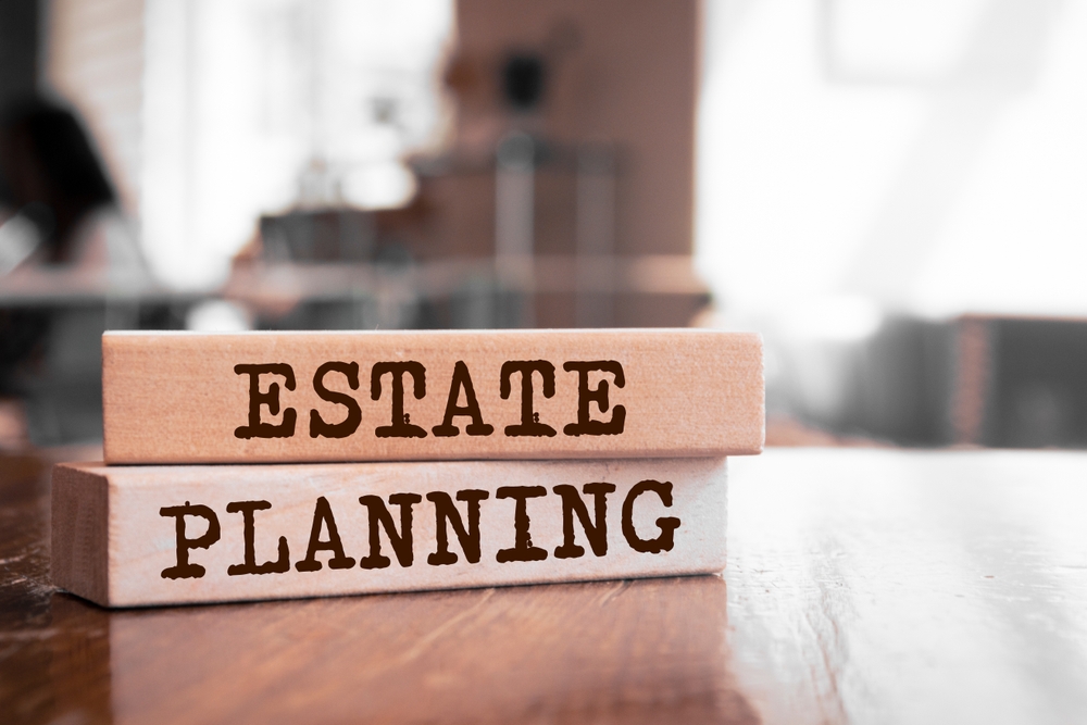 Wooden blocks on a table spelling out "Estate Planning," highlighting the significance of efficient estate planning to avoid lengthy probate proceedings.