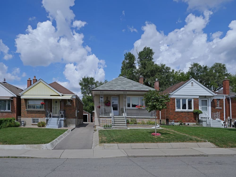 A street lined with 1950s-style working-class bungalows, representing the challenges families face due to Medicaid estate recovery rules in estate planning and elder law.
