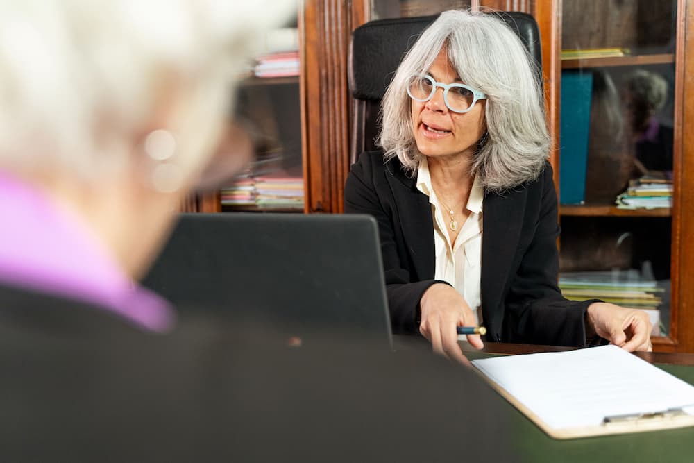 A senior woman consults with an experienced female elder law attorney about long-term care planning options.