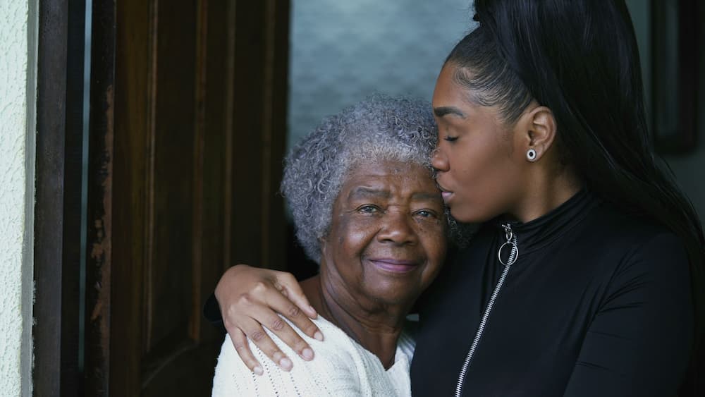 A young woman lovingly embraces her elderly mother, illustrating the familial bond and support amidst discussions on the financial implications of long-term care and estate planning in elder law.