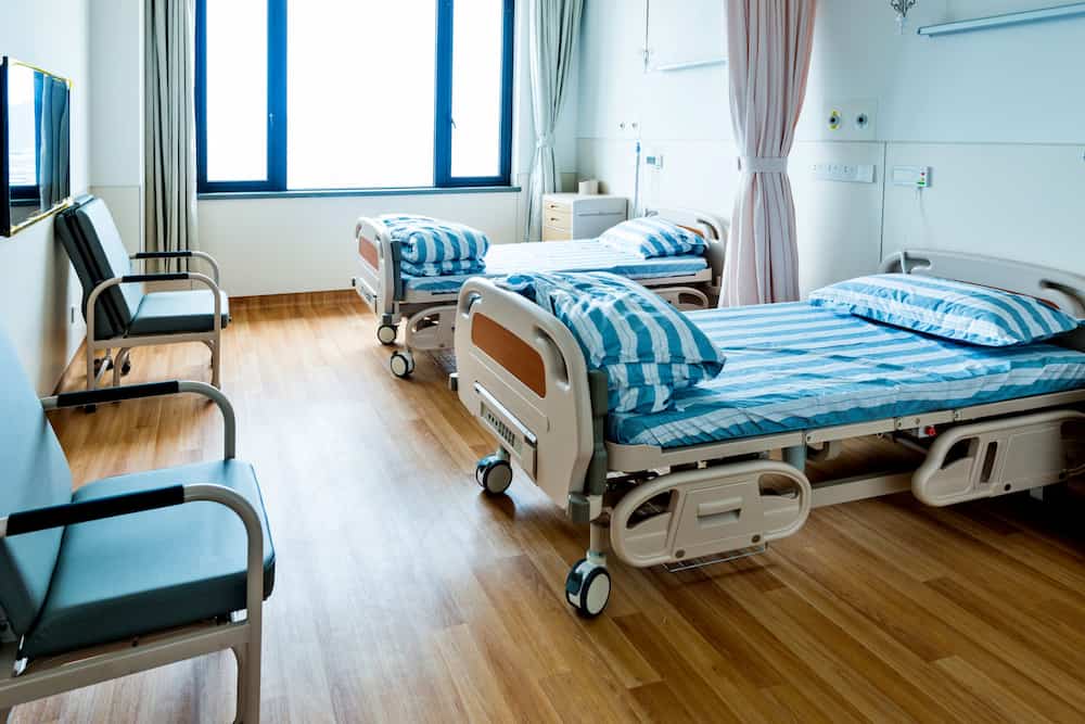 An empty nursing home patient room with two beds, reflecting challenges in nursing home evictions and the importance of understanding elder law rights.