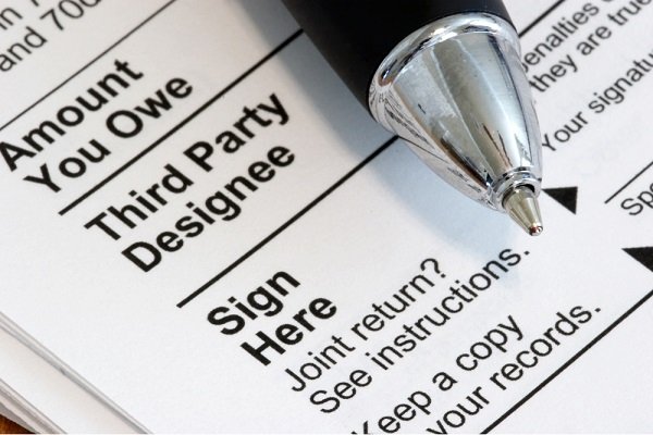 Senior couple reviewing IRS documents at home, exploring payment options and uncollectible status for managing back taxes.