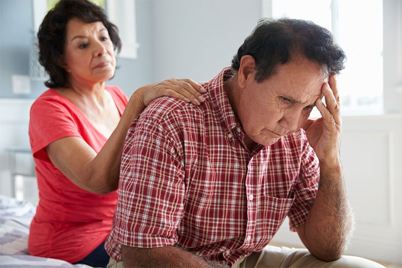 An elderly couple sitting closely, symbolizing support and care in estate planning for mental illness.