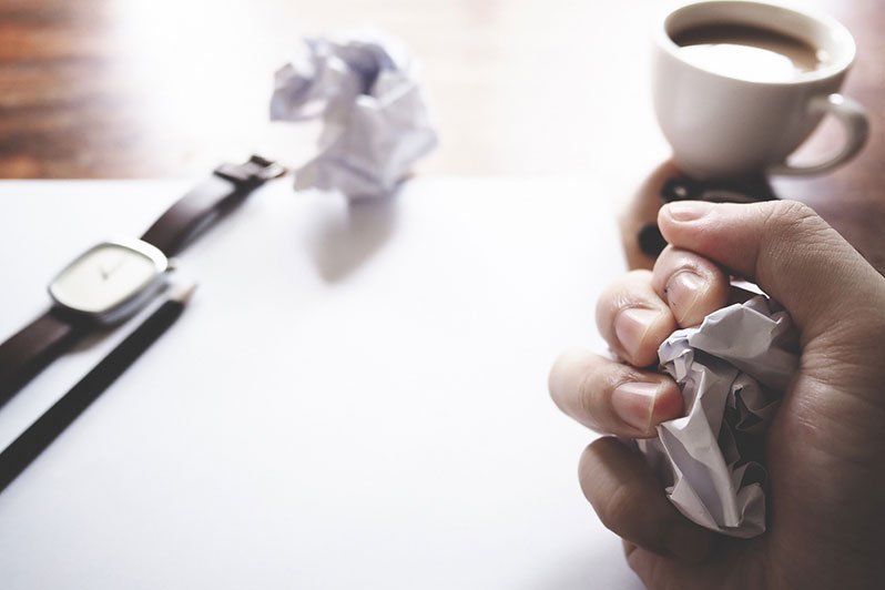 Frustrated man sitting at his desk with financial documents, symbolizing the challenges of traditional asset protection plans in estate planning and elder law.