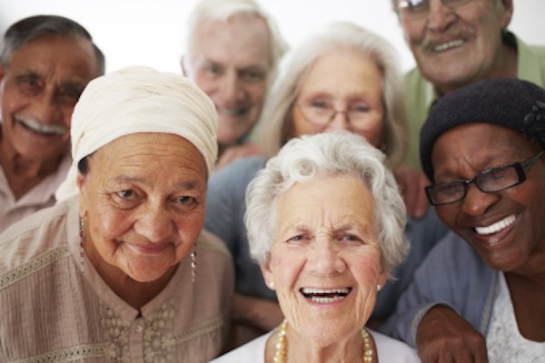 A group of older adults engaged in conversation, highlighting the importance of understanding New Jersey Medicaid support programs for seniors.