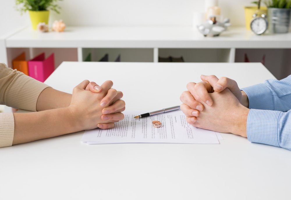 A person reviewing estate planning documents, highlighting the importance of updating legal documents such as wills and trusts before a divorce.