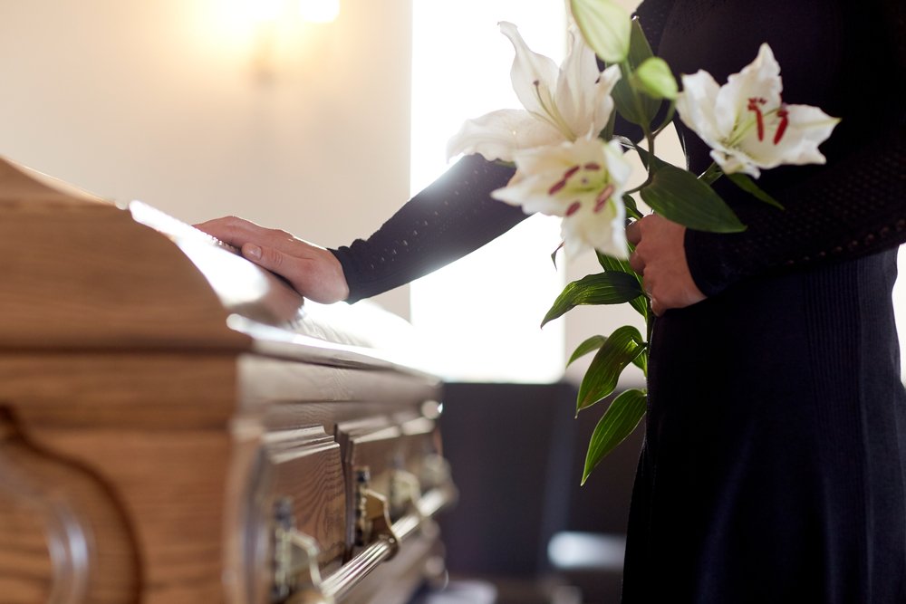 Two women sitting at a table looking at documents, discussing estate planning and elder law after a loved one's passing.