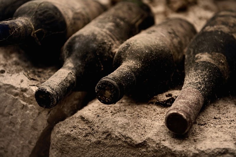 A vintage bottle of red wine and a glass, symbolizing the concept of decanting an irrevocable trust to improve its terms over time.