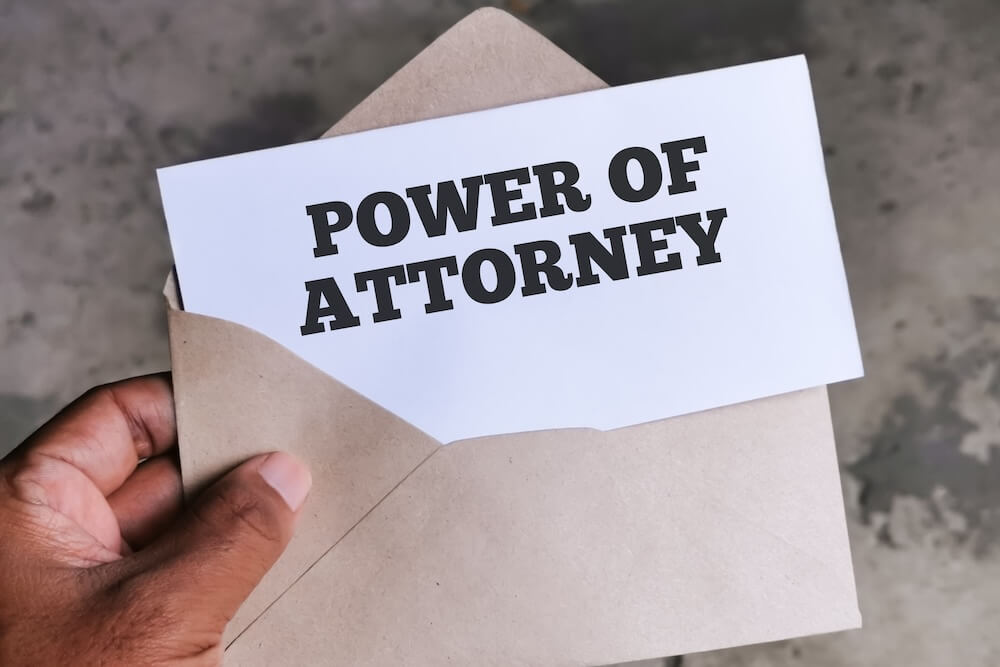 A Power of Attorney document partially visible in a brown envelope, symbolizing legal authority and incapacity planning.