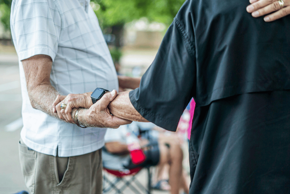 Older adults holding hands while discussing estate planning decisions
