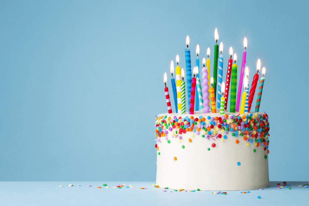 Birthday cake with candles representing turning 65 and important Medicare enrollment deadlines.