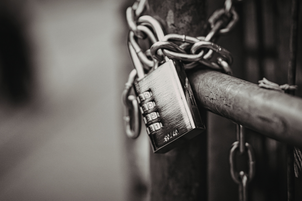Chain and padlock securing a metal gate, symbolizing a no-contest clause used to discourage challenges to a will or trust.